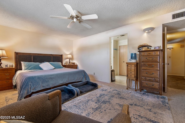 bedroom featuring ceiling fan, light colored carpet, and a textured ceiling