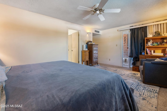 bedroom featuring ceiling fan, carpet, and a textured ceiling