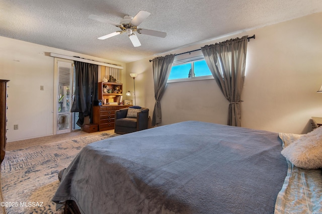 bedroom featuring ceiling fan, carpet, and a textured ceiling