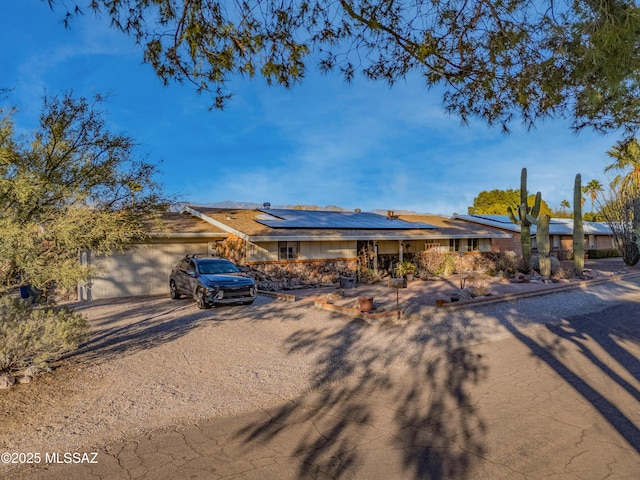 view of front facade with solar panels and a garage