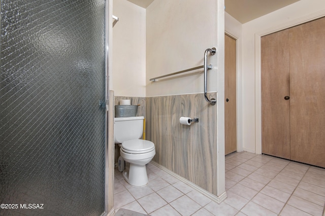 bathroom with tile walls, toilet, and tile patterned flooring