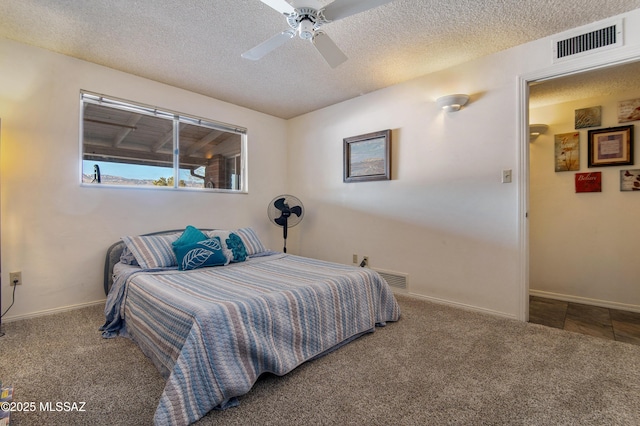 bedroom featuring ceiling fan, carpet floors, and a textured ceiling