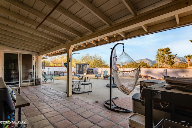 view of patio / terrace with a storage shed and a mountain view