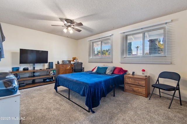 carpeted bedroom featuring a textured ceiling and ceiling fan