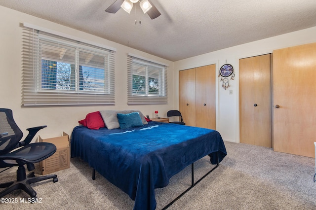 carpeted bedroom with ceiling fan and a textured ceiling