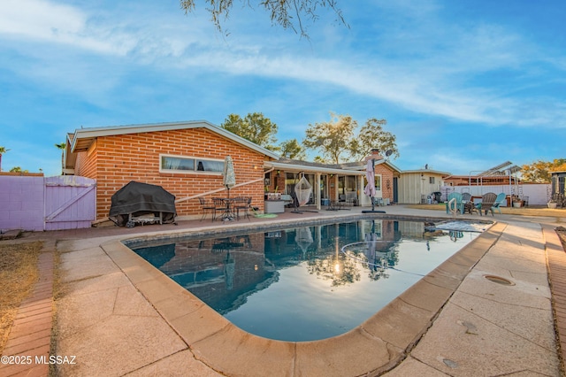 view of swimming pool with a patio area and a grill