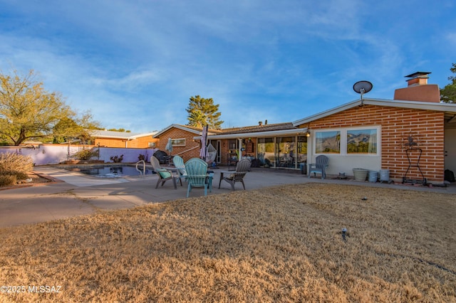 back of house with a yard and a patio