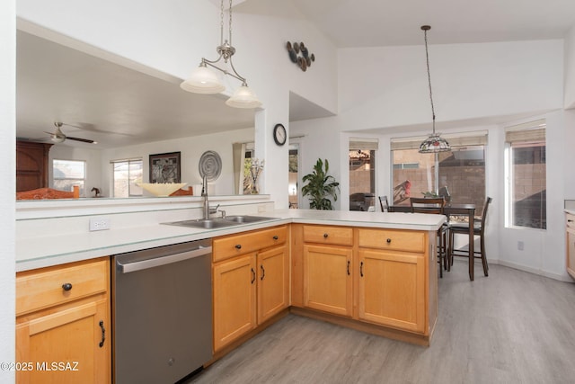 kitchen with decorative light fixtures, dishwasher, light hardwood / wood-style floors, and kitchen peninsula