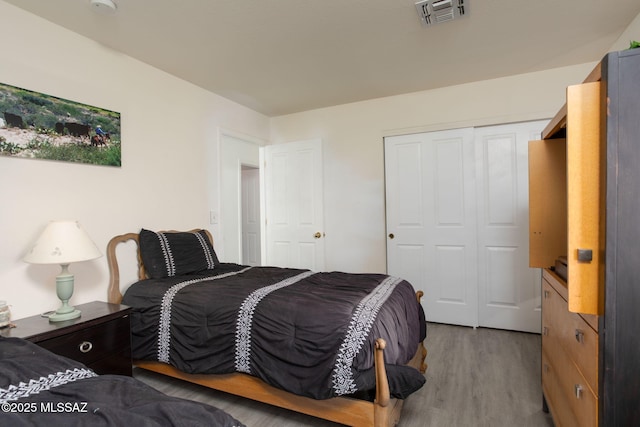 bedroom with wood-type flooring and a closet