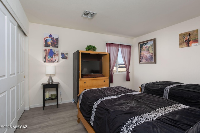 bedroom with hardwood / wood-style floors and a closet