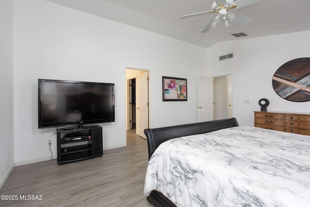 bedroom with ceiling fan, lofted ceiling, and wood-type flooring