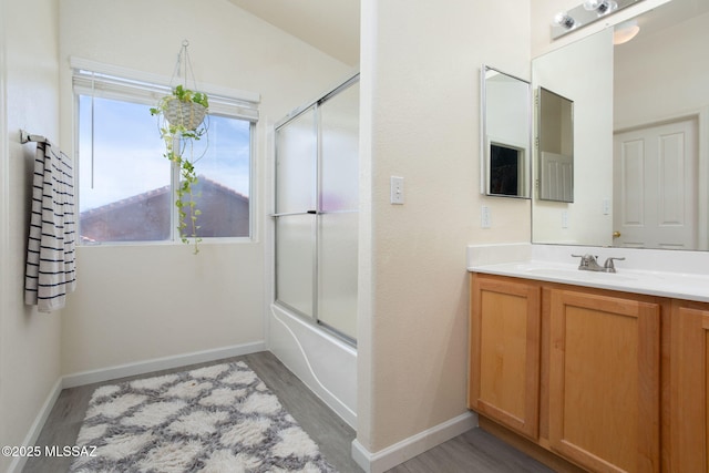 bathroom featuring vanity, bath / shower combo with glass door, and wood-type flooring