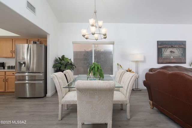 dining area with a chandelier and light hardwood / wood-style flooring