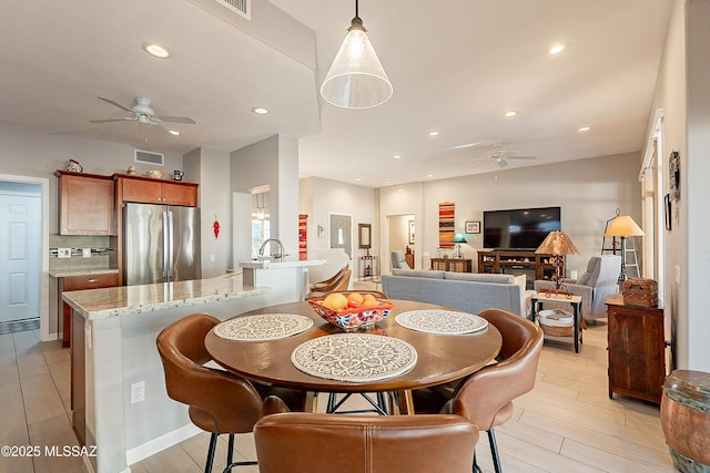 dining room with ceiling fan and light hardwood / wood-style flooring