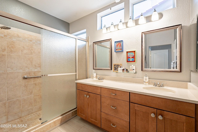 bathroom featuring vanity, a shower with shower door, and tile patterned flooring