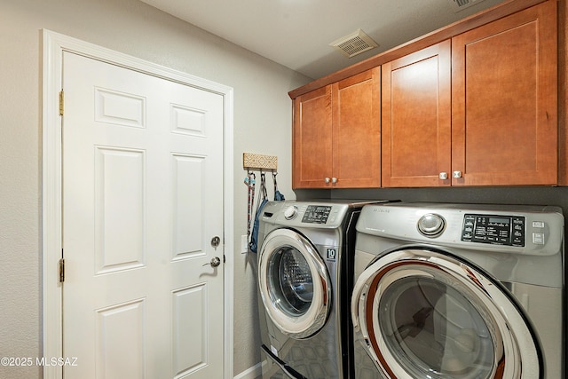 clothes washing area featuring independent washer and dryer and cabinets