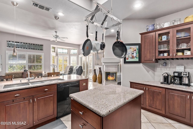 kitchen featuring sink, light tile patterned floors, black dishwasher, a kitchen island, and ceiling fan