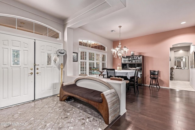 foyer with an inviting chandelier and hardwood / wood-style floors