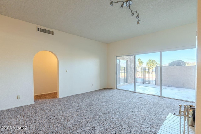 carpeted empty room with a textured ceiling