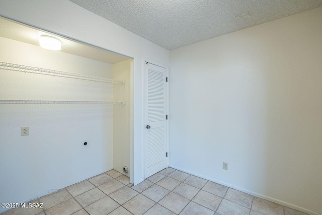 washroom with hookup for an electric dryer and a textured ceiling