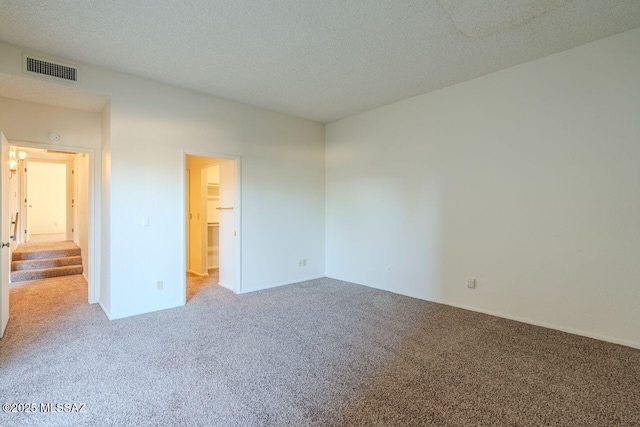 unfurnished room featuring carpet flooring and a textured ceiling