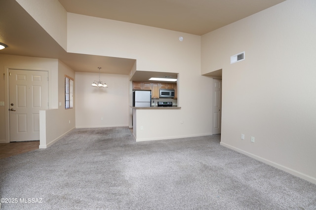 unfurnished living room with light carpet and an inviting chandelier