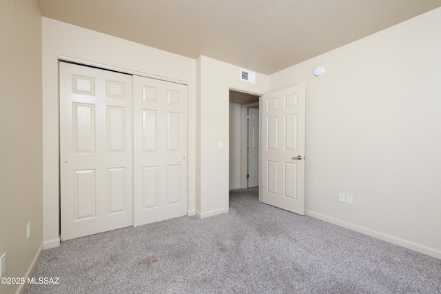 unfurnished bedroom with light carpet and a closet