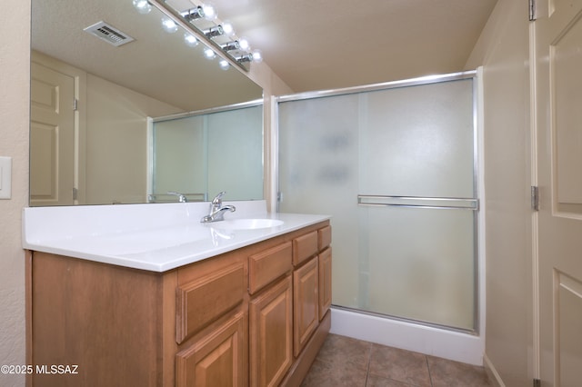 bathroom featuring tile patterned flooring, vanity, and an enclosed shower