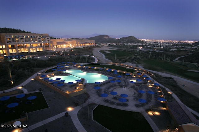 pool at dusk featuring a mountain view