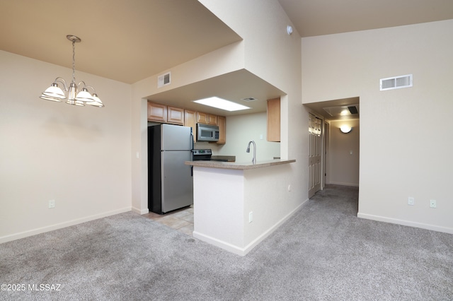 kitchen featuring decorative light fixtures, a chandelier, appliances with stainless steel finishes, kitchen peninsula, and light colored carpet