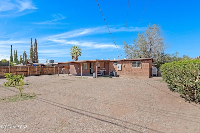 back of property with central AC unit and a patio