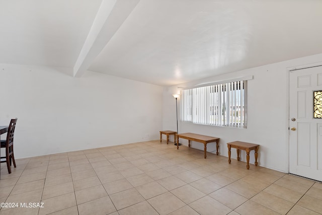 tiled foyer entrance featuring beam ceiling