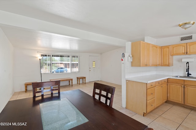 kitchen with sink, light brown cabinets, and light tile patterned floors