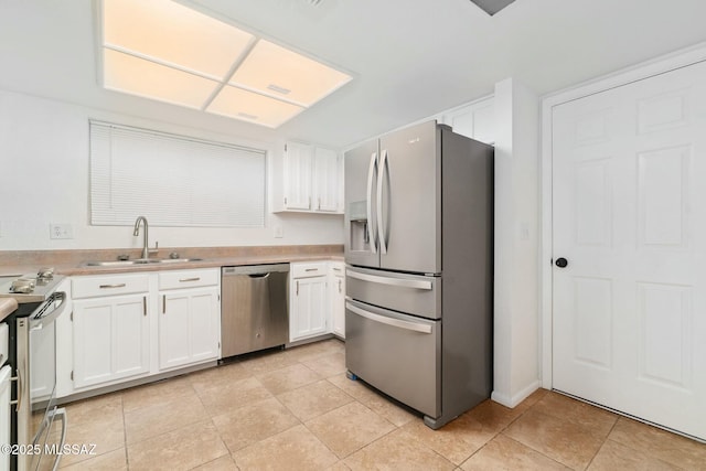 kitchen featuring light tile patterned flooring, stainless steel appliances, sink, and white cabinets