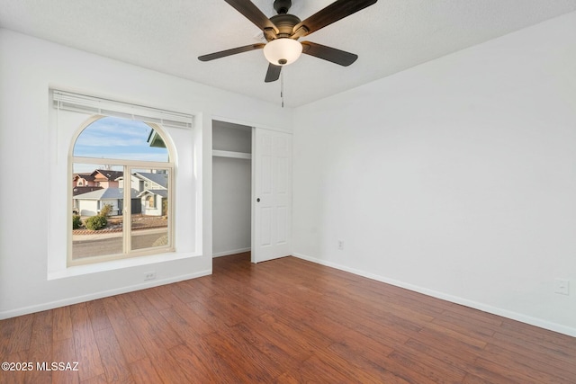 unfurnished bedroom with ceiling fan, wood-type flooring, and a closet