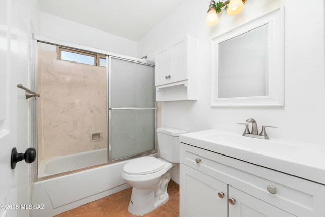 full bathroom with bath / shower combo with glass door, toilet, tile patterned floors, and vanity