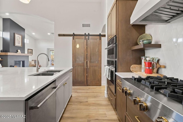 kitchen featuring appliances with stainless steel finishes, custom range hood, sink, and backsplash