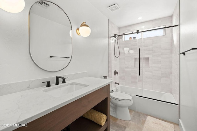 full bathroom featuring toilet, vanity, and shower / bath combination with glass door