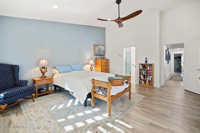 bedroom featuring light hardwood / wood-style flooring, high vaulted ceiling, and ceiling fan