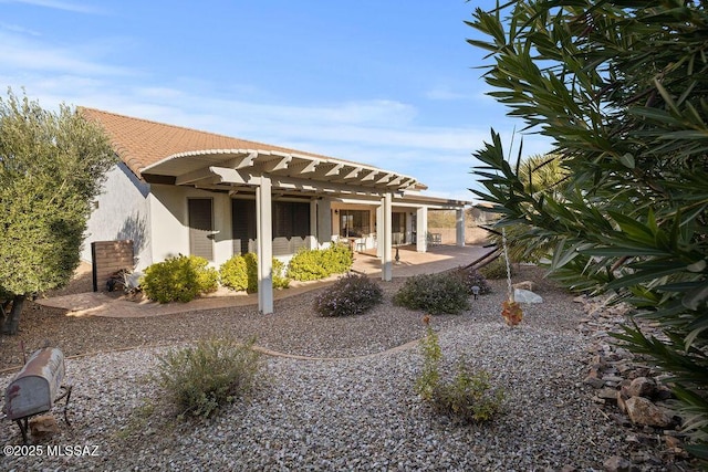 back of house with a pergola and a patio