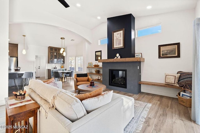 living room with lofted ceiling and a large fireplace