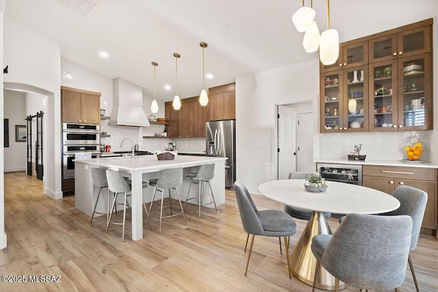 dining space featuring sink, wine cooler, and light hardwood / wood-style floors