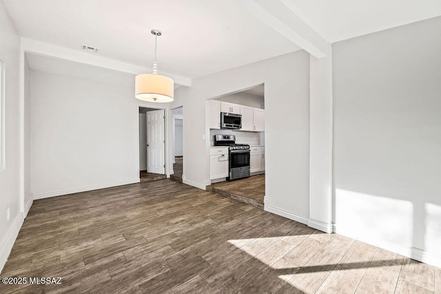 unfurnished living room with dark hardwood / wood-style flooring and beam ceiling