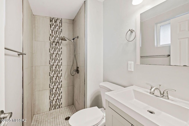 bathroom featuring vanity, toilet, and tiled shower