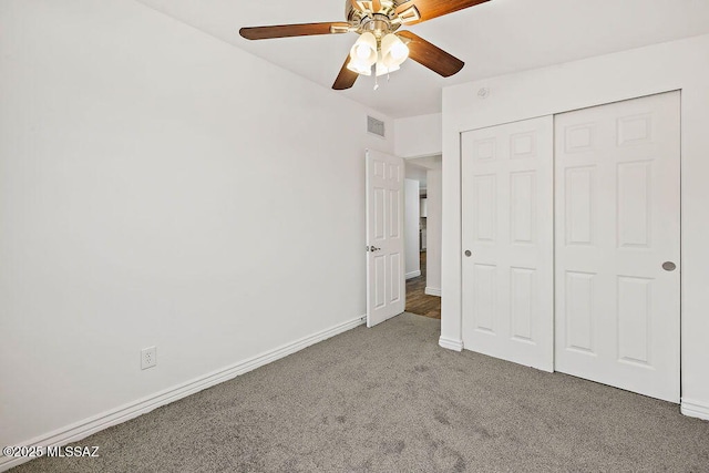 unfurnished bedroom featuring carpet, ceiling fan, and a closet