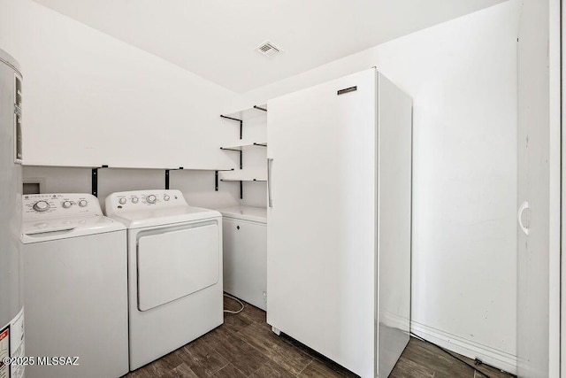 clothes washing area with dark hardwood / wood-style flooring and washer and dryer