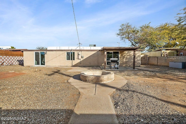 rear view of house with a patio and a fire pit