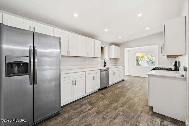 kitchen featuring sink, appliances with stainless steel finishes, white cabinetry, hanging light fixtures, and dark hardwood / wood-style floors