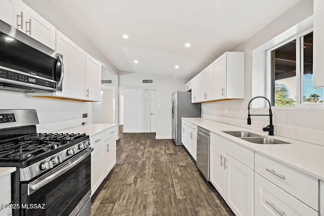 kitchen featuring dark hardwood / wood-style flooring, sink, white cabinets, and appliances with stainless steel finishes