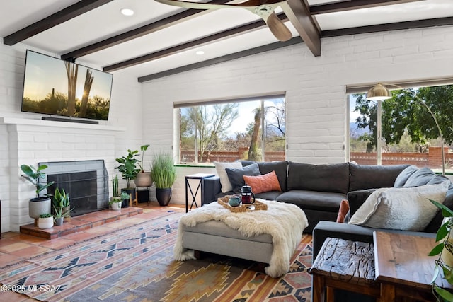 living room with lofted ceiling with beams, brick wall, and a fireplace